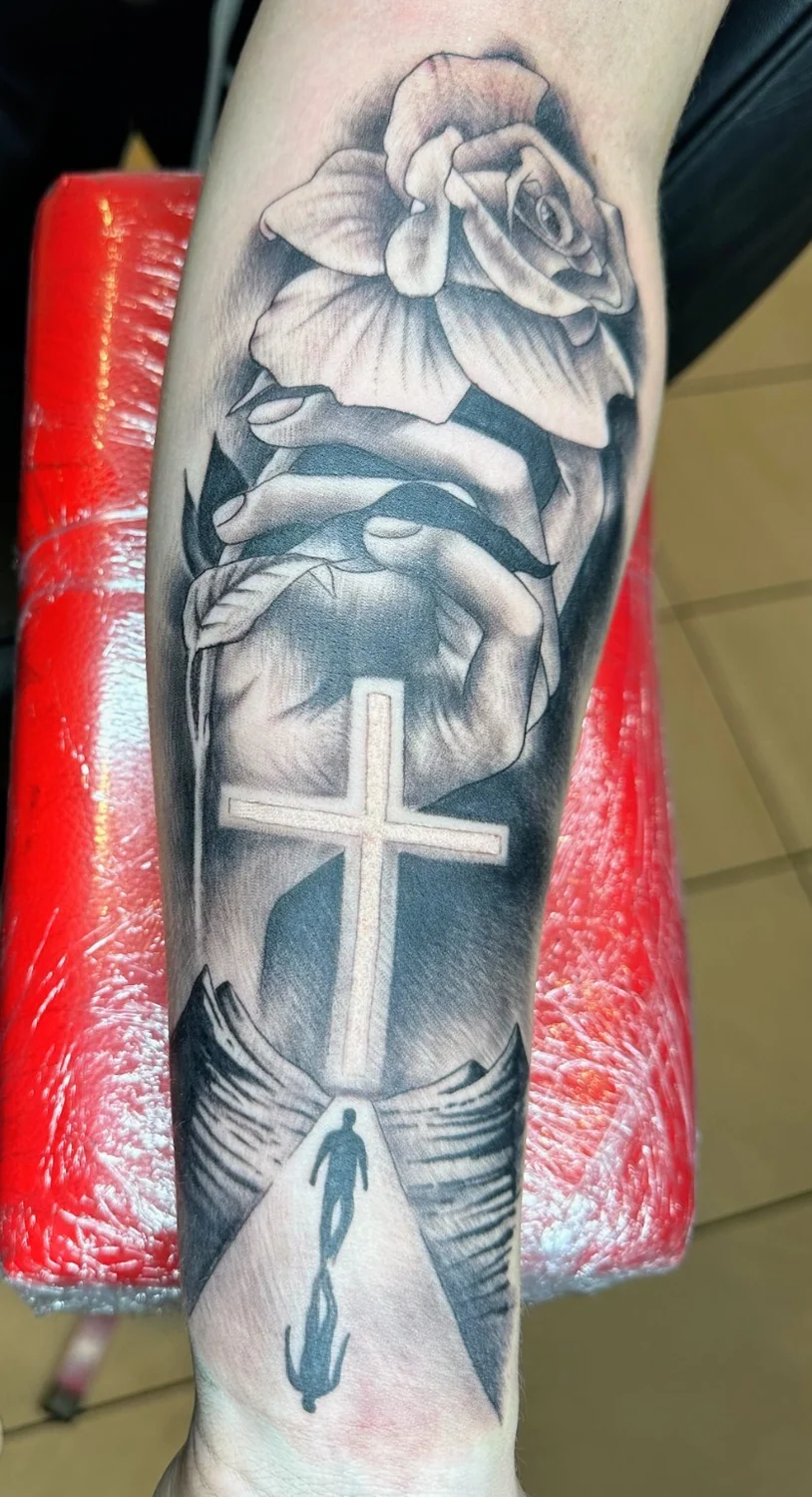 Kreuz, Hände und Blüte – Tattoo-Arbeit von Silence