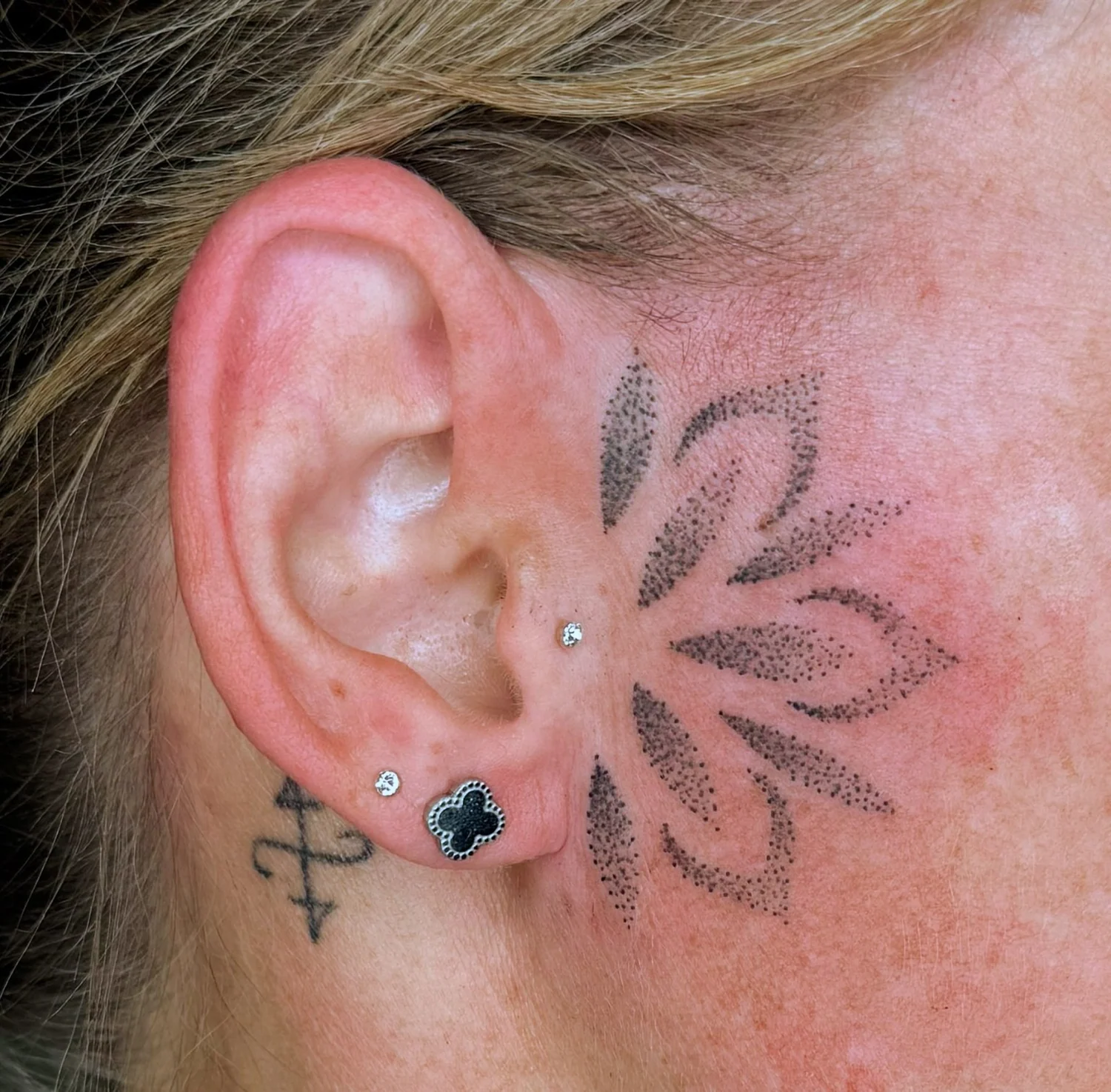 Florales Motiv hinter dem Ohr – Tattoo-Arbeit von Silence