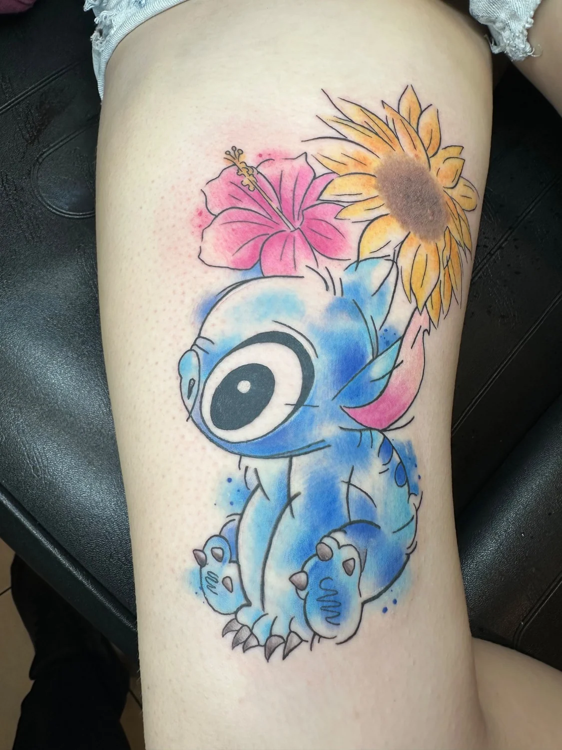 Stitch mit Blumen in Farbe – Tattoo-Arbeit von Silence