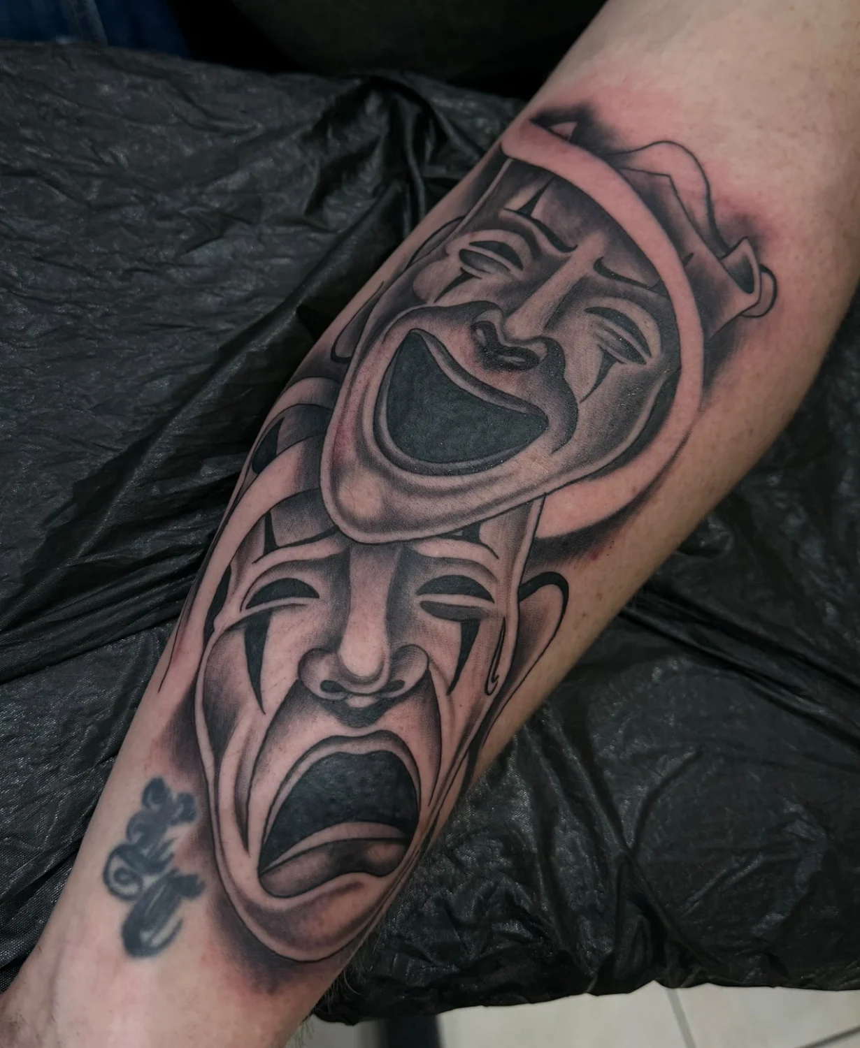 Theatermasken auf dem Arm – Tattoo-Arbeit von Silence