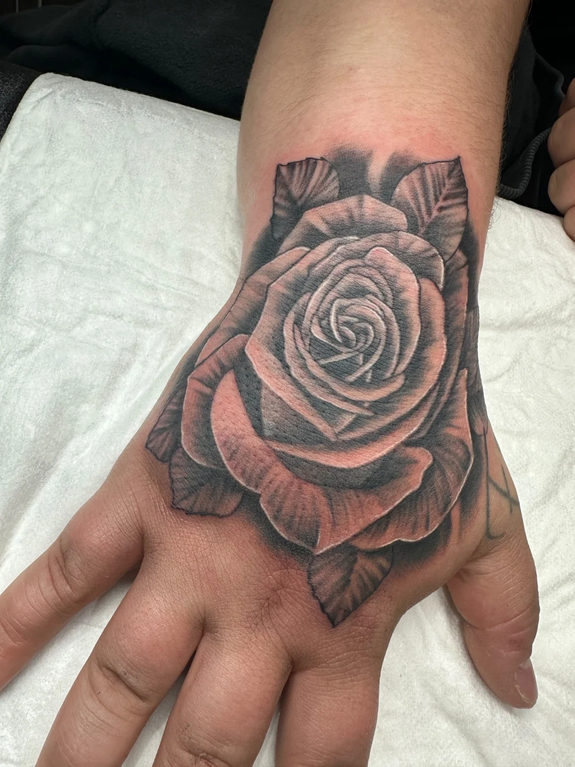 Rose auf dem Handrücken – Tattoo-Arbeit von Silence