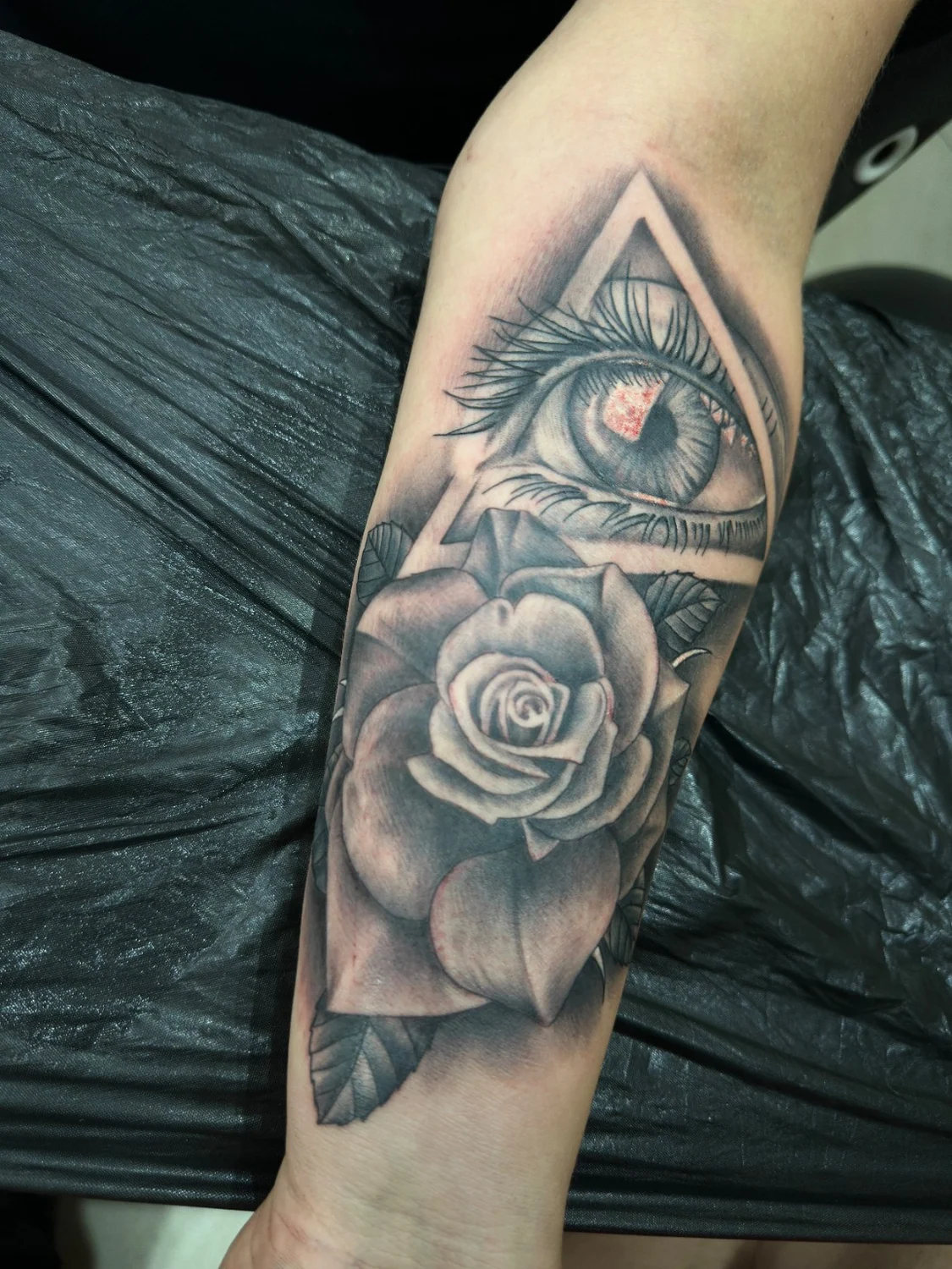 Auge und Rose auf dem Unterarm – Tattoo-Arbeit von Silence