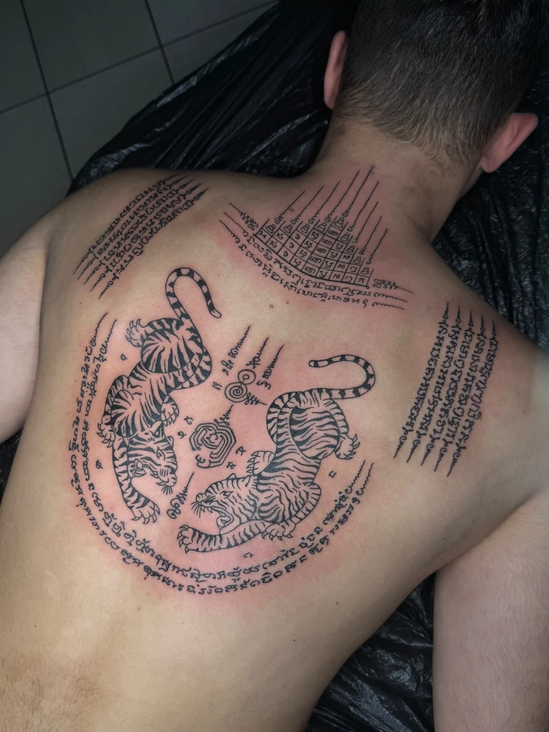 Schriftzeichen und Symbol auf dem Rücken – Tattoo-Arbeit von Silence