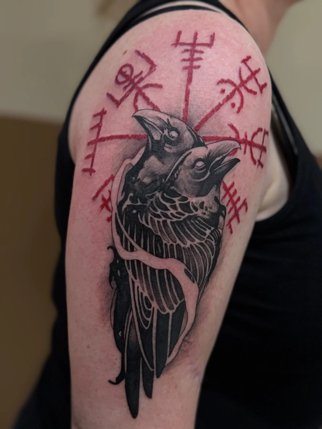 Rabe mit roten Symbolen – Tattoo-Arbeit von Silence