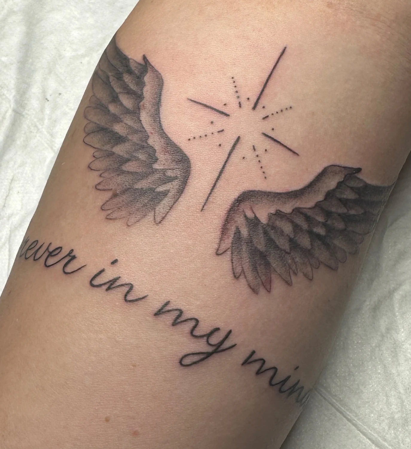 Flügel mit Schriftzug – Tattoo-Arbeit von Silence
